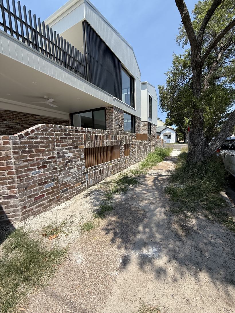 Finished recycled-brick front fence with timber batten inserts
