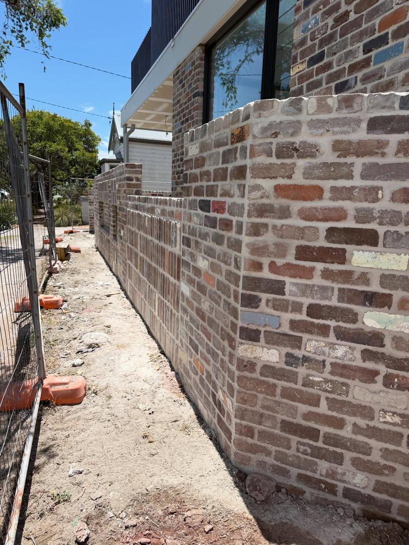 Recycled-brick fence running along a side path